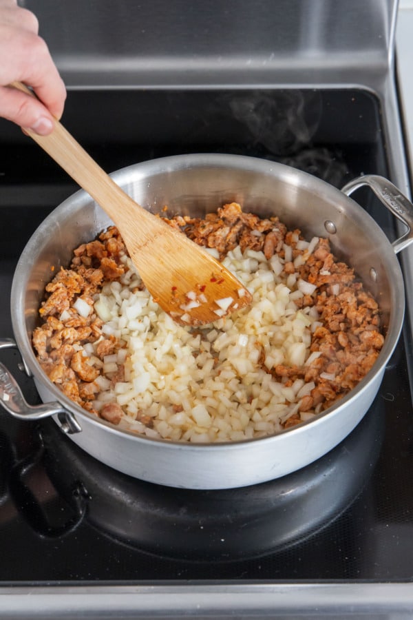 Cooking onion in a stainless skillet until softened and translucent.