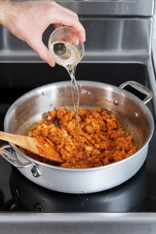 Adding white white to skillet along with sausage mixture and flour.