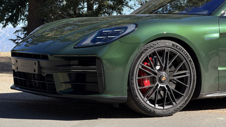 Front bumper and wheel of a green 2025 Porsche Panamera GTS