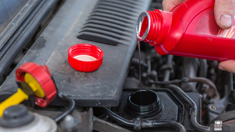 Mechanic pouring power steering fluid into the reservoir